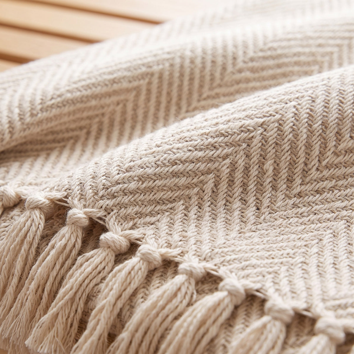 Close-up of the herringbone weave and knotted tassel fringe of the oatmeal throw
