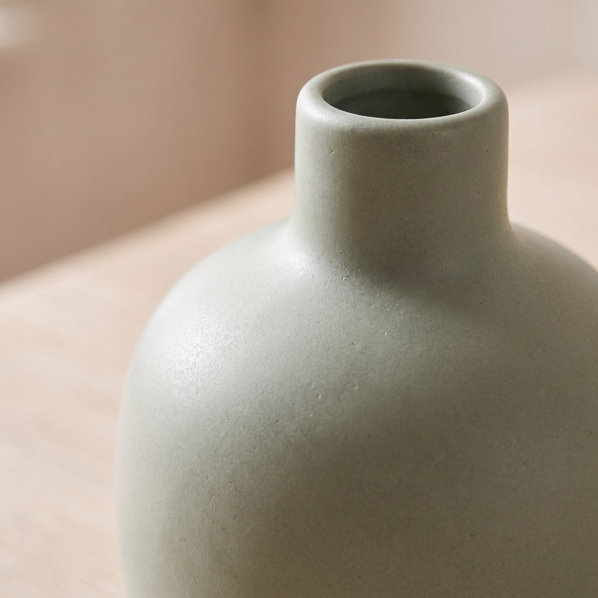 Close-up of the narrow neck and matte sage glaze of the stoneware bud vase